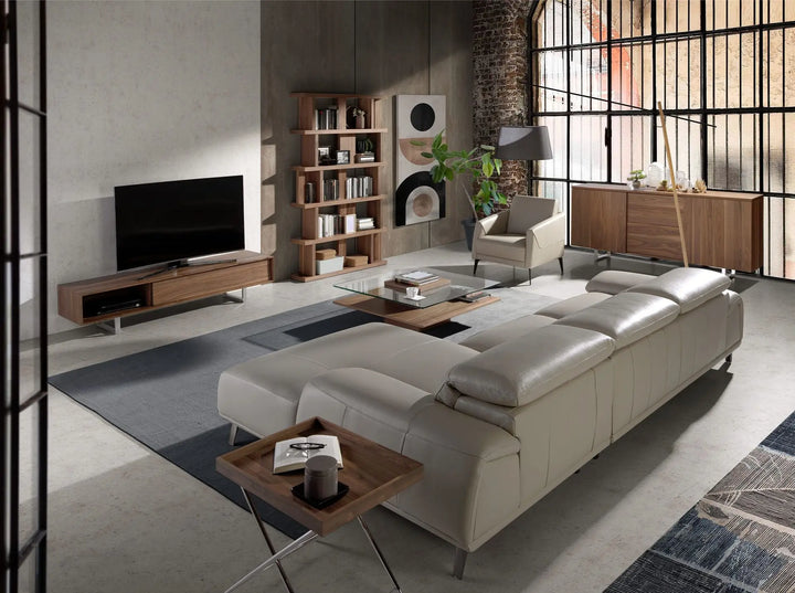 sofá moderno tapizado en piel beige, con asientos amplios, respaldo reclinable y patas metálicas

