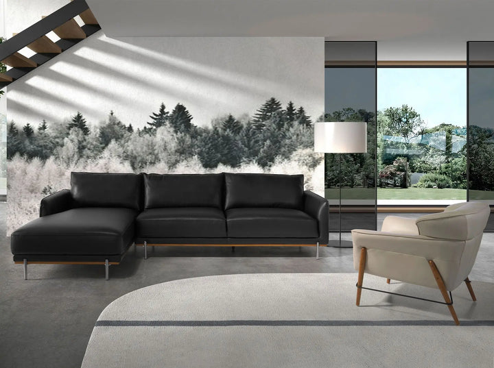 sofá moderno esquinero en piel negra con patas metálicas y acento de madera en la base