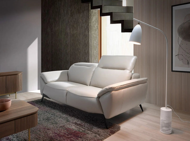 sofá reclinable moderno en piel beige claro con respaldo alto y patas metálicas negras, ideal para sala contemporánea